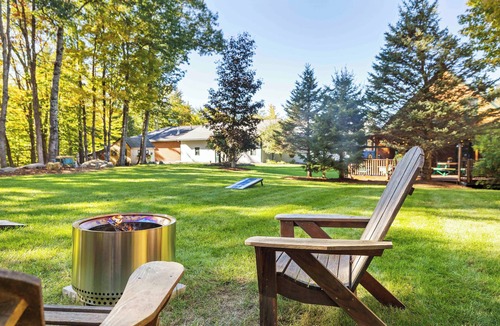 Holderness House | Central Escape is a spacious Lakes Region retreat just 5 minutes from downtown Meredith, less than a mile to Squam Lake and 20 minutes to concerts at the Bank of New Hampshire Pavilion. Enjoy the private year-round hot tub, fire pit, yard games!